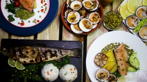 Meals from trout and dog cockles served on wooden table — Stock Video