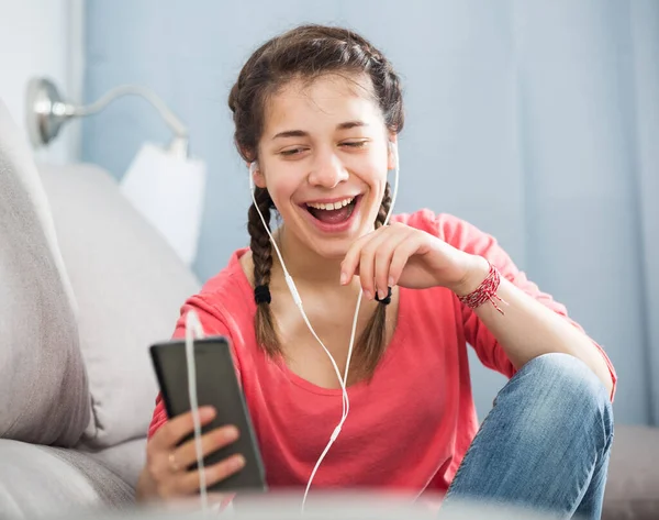 Ung Flicka Kollar Sin Telefon Och Lyssnar Musik Hemma — Stockfoto