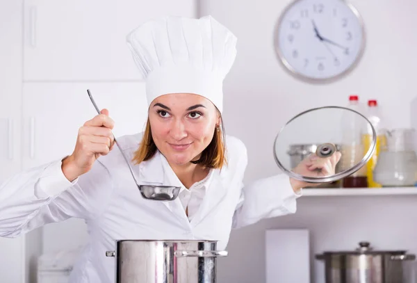 Young Female Cook Tasting Food While Preparing Kitchen — Stock Photo, Image
