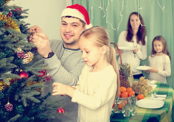 Vrolijke Glimlachende Ouders Met Twee Schattige Kleine Dochters Versieren Kerstboom — Stockfoto