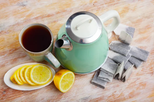 Bollitore elettrico e tazza di tè sul tavolo — Foto Stock