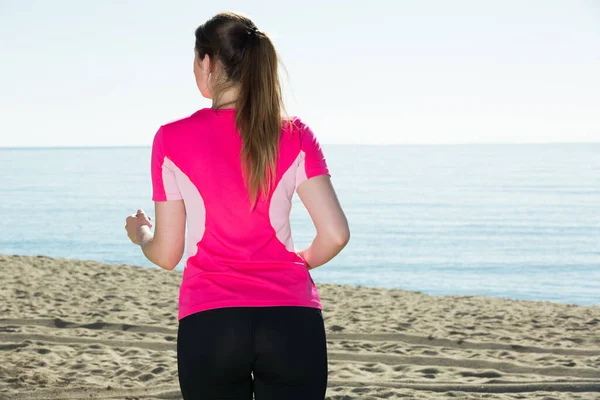 Mujer esbelta corriendo en la playa —  Fotos de Stock