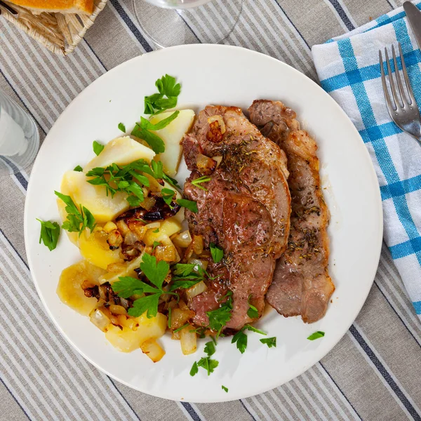 Porc frit appétissant aux pommes de terre et aux herbes — Photo