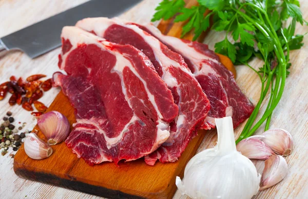 Närbild av rå kalv på träytan med ingredienser — Stockfoto