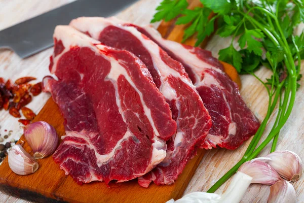 Nyers, szeletelt marhahús friss petrezselyemmel — Stock Fotó