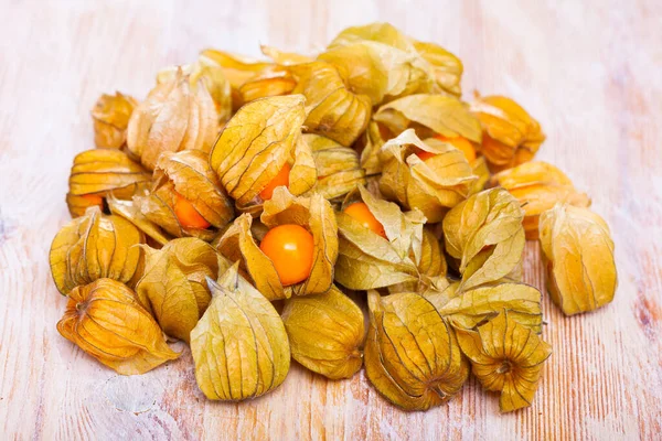 Primo piano di frutta di physalis matura gialla su tavolo di legno. Frutta e verdura, alimentazione vegetariana e sana — Foto Stock