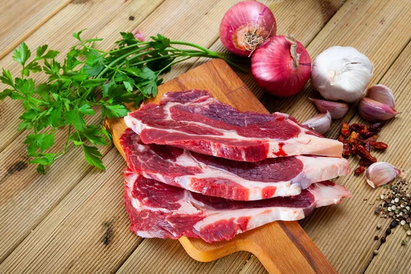 요리하지 않은 쇠고기 국물 과 파 아슬리 와 마늘을 식탁에 얹어 놓고 — 스톡 사진
