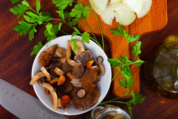 Assorted pickled mushrooms with parsley and sliced onions — Stock Photo, Image