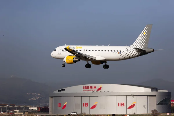 Aeronaves Vueling aterriza en la pista de aterrizaje en un aeropuerto de la ciudad de El Prat de Barcelona. Número de la Junta EC-LOB — Foto de Stock