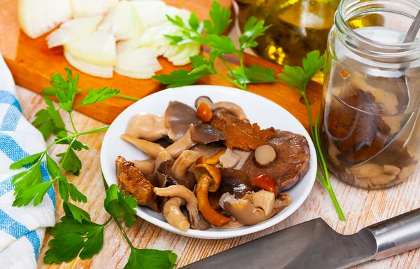 Geassorteerde gepekelde champignons met peterselie en gesneden uien — Stockfoto