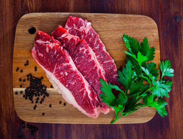 Filete de ternera crudo con cebolla y pimienta listo para cocinar en la mesa — Foto de Stock