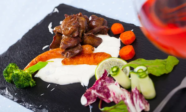 Delicious fried chicken hearts with cream sauce and vegetables — Stock Photo, Image