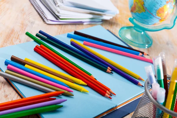 Varios lápices de colores y cuadernos en una mesa de madera —  Fotos de Stock