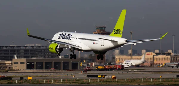 Aerolínea Airbaltic avión llega para un aterrizaje en un aeropuerto El Prat ciudad de Barcelona — Foto de Stock