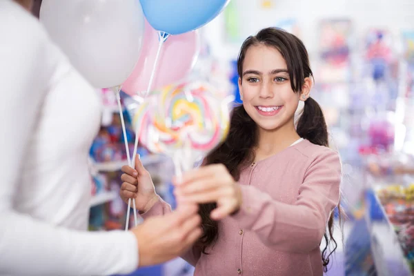 Girl with balloons receives lollipop — Stock Photo, Image