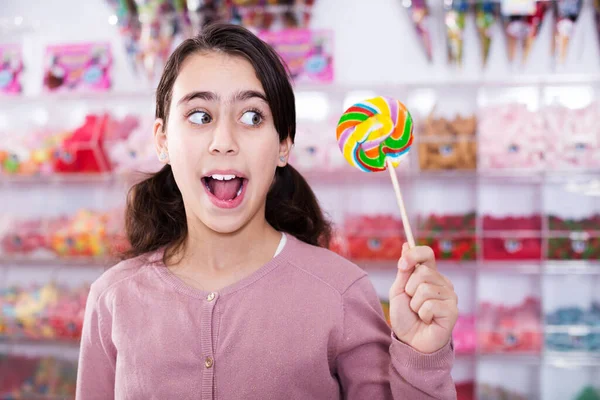 Emotional schoolgirl with lollipop — Stock Photo, Image