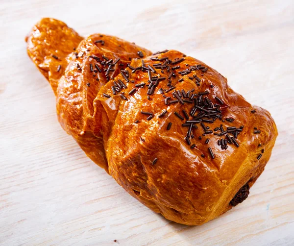 Czekoladowy rogalik ślimakowy, francuski deser na drewnianej powierzchni — Zdjęcie stockowe