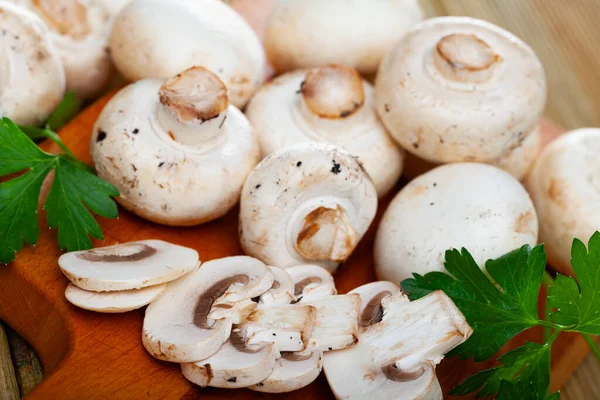 Closeup of whole raw fresh champignon mushroom on a white wooden table. Mushrooms as vegetable protein, raw food diet, vegetarianism — Stock Photo, Image