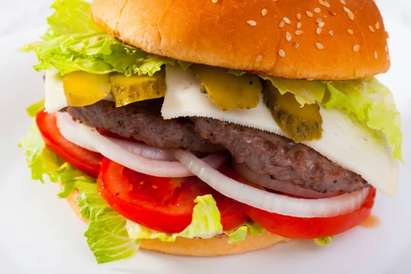 Dvojitý cheeseburger s hovězím masem, rajčaty, sýrem, okurkou a salátem — Stock fotografie