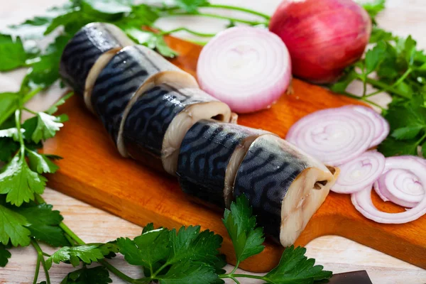 Lightly salted mackerel cut into pieces with parsley and onion on table — Stock Photo, Image