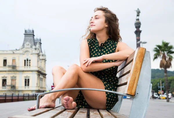Sexy žena turista v šatech sedí na dřevěné lavičce v historickém centru — Stock fotografie