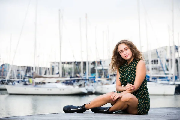 Junge sexy Touristin in Kleid posiert verspielt am Kai mit Booten — Stockfoto
