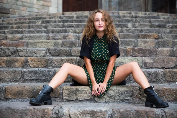 Joven chica sexy turista en vestido sentado en la escalera de piedra en el centro de Barcelona — Foto de Stock
