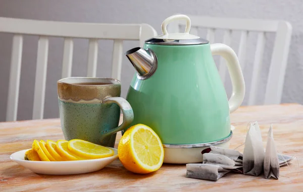 Yeni çaydanlık siyah çay ve dilimlenmiş limonla birlikte masada. — Stok fotoğraf