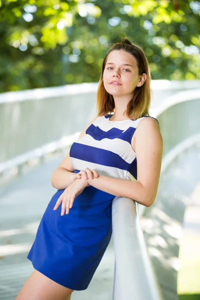 Chica atractiva posando en el puente en el parque de la ciudad — Foto de Stock