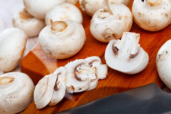 Cogumelos de champignon frescos em uma tábua de corte de madeira — Fotografia de Stock