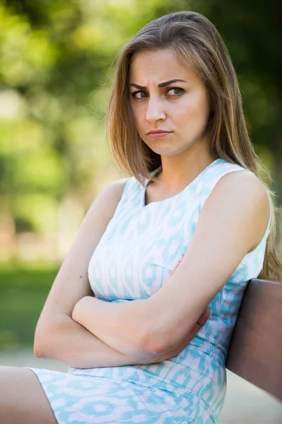 Portrait of frustration young woman sitting in outdoor — Stock Photo, Image