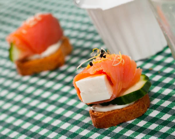 Canapé com salmão, queijo mole jovem, pepino — Fotografia de Stock