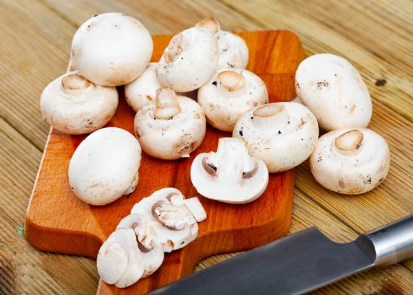 Close-up of cut fresh raw champignons on wooden desk — Stock Photo, Image