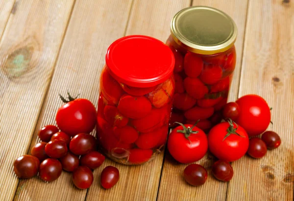 Маринованные помидоры в банке, с ингредиентами — стоковое фото