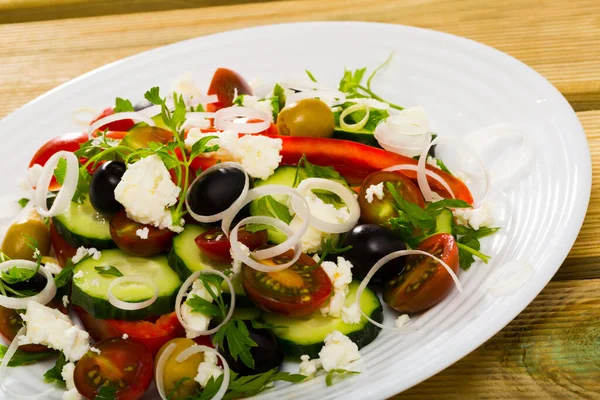 Салат из балканской кухни со свежими овощами, сыром брынза и луком — стоковое фото