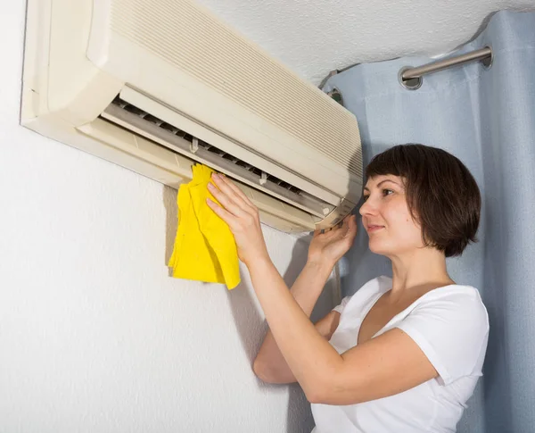 Woman cleaning air conditioner — Stock Photo, Image