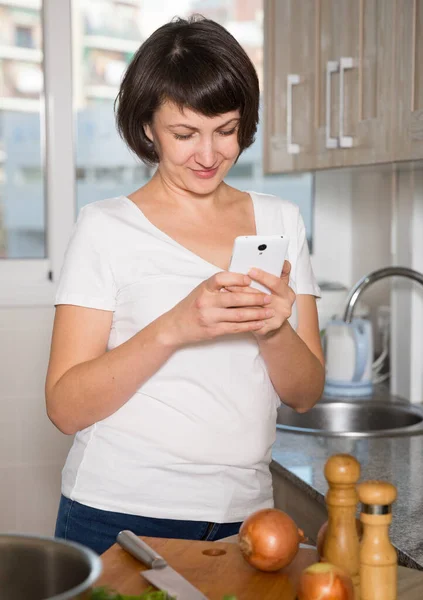 Kvinnan läser nyheter på sin smartphone — Stockfoto