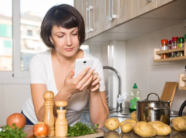 Dona de casa mensagens em seu gadget — Fotografia de Stock