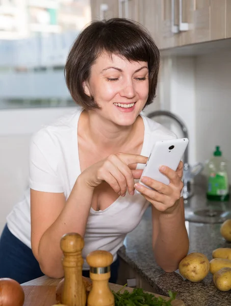 Kvinnan läser nyheter på sin smartphone — Stockfoto