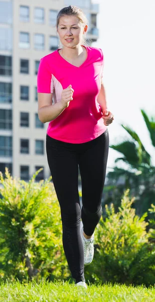 Young girl in pink T-shirt is running — Stock Photo, Image