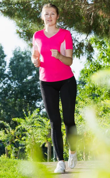 Kvinna i rosa T-shirt är träning — Stockfoto