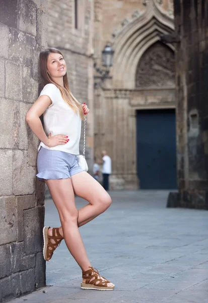 Romantic girl leaning against stone wall — Stock Photo, Image