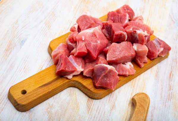 Sabroso cerdo crudo en rodajas antes de cocinar en la superficie de madera — Foto de Stock
