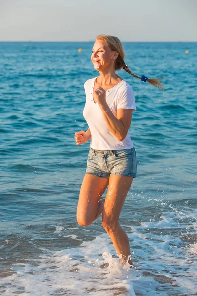 Kvinna i vit T-shirt är jogging — Stockfoto