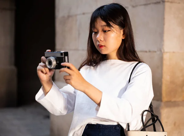 A fiatal kínai lány fényképeket készít a kamerájával, miközben a városon keresztül utazik. — Stock Fotó