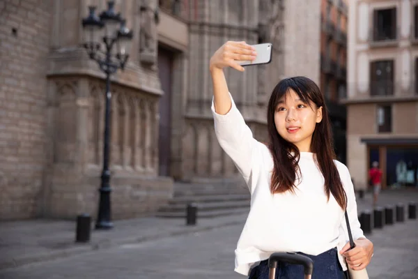 Mooie vrouwelijke toerist maken selfie op de achtergrond van oriëntatiepunt — Stockfoto