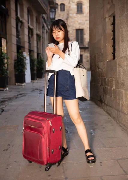 Toeristisch Chinees meisje met behulp van haar telefoon in de stad op vakantie — Stockfoto