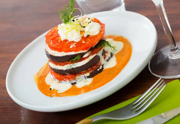 Sabrosas berenjenas fritas con tomates en salsa blanca y picante en el plato — Foto de Stock