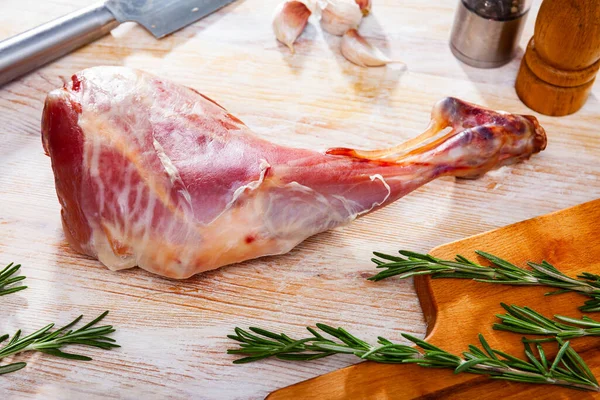 Syrová jehněčí noha s rozmarýnem a česnekem. Čerstvé a syrové maso — Stock fotografie