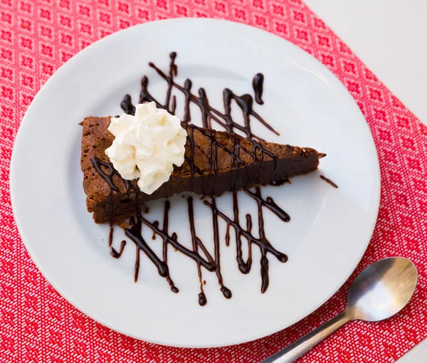 Bolo de brownie doce com creme de chocolate e manteiga servido no prato — Fotografia de Stock